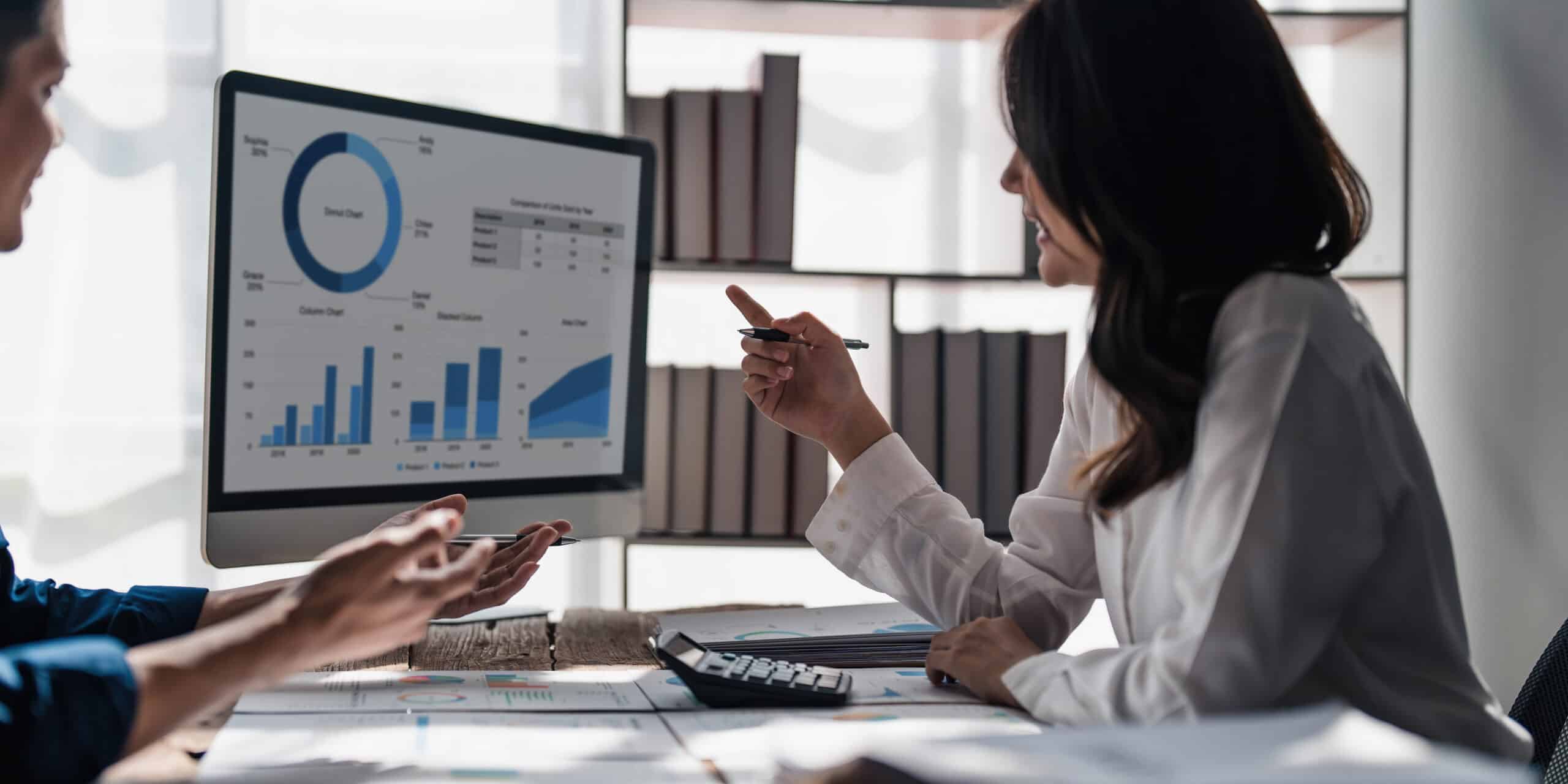 Two business people talk project strategy at office meeting room. Businessman discuss project planning with colleague at modern workplace while having conversation and advice on financial data report...